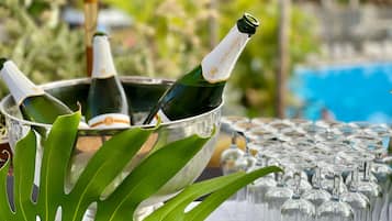A table with a metal bucket containing bottles, surrounded by empty wine glasses.