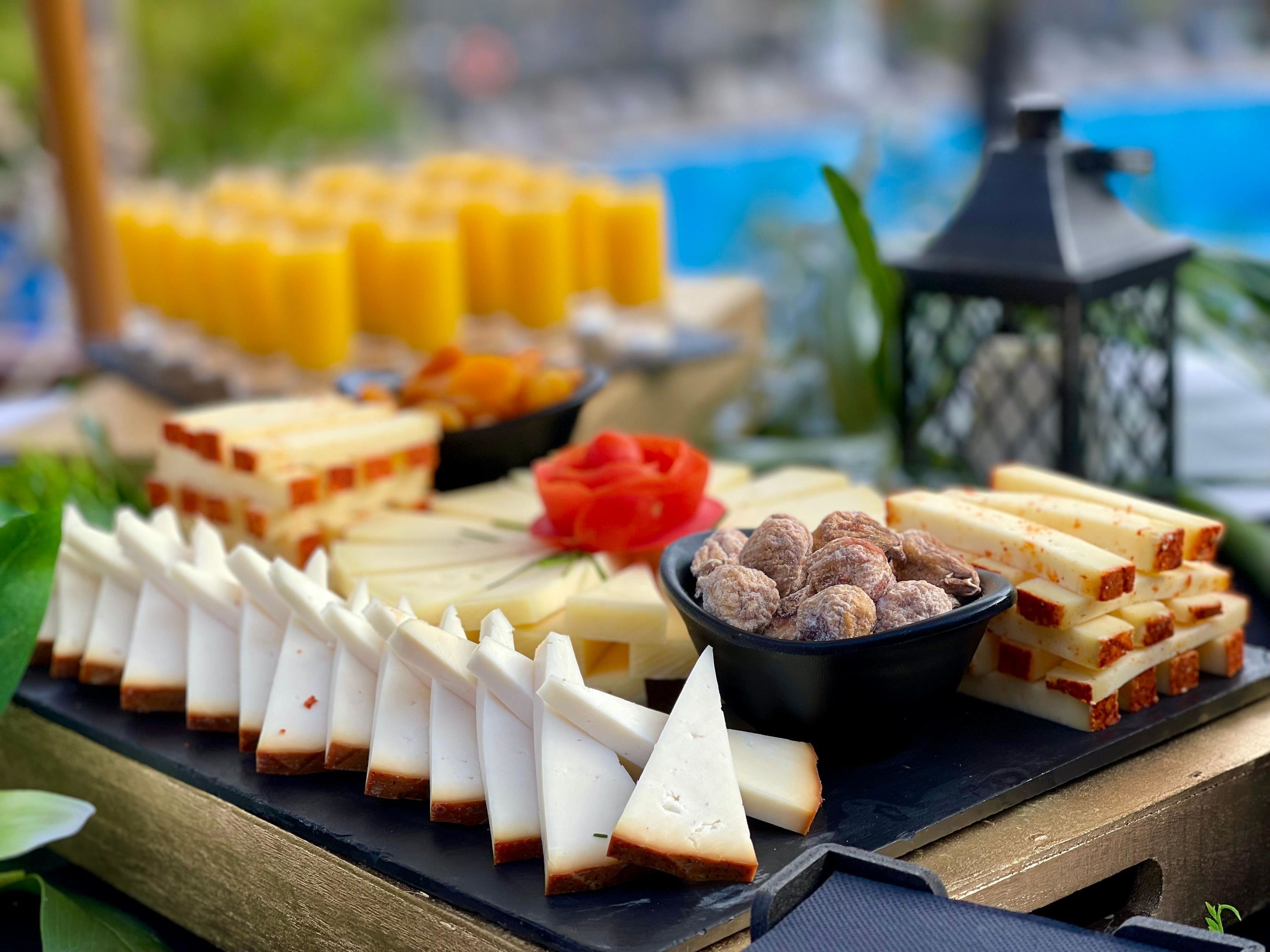 A buffet with various cheeses, meats, and fruits.