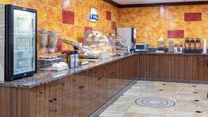 A hotel breakfast area with a self-service station, a refrigerator, and a microwave. - Days Hotel by Wyndham North Bergen /NYC Area (North Bergen)