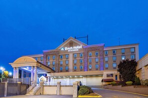 A Days Hotel by Wyndham with a large entrance, multiple floors, and a well-lit facade. - Days Hotel by Wyndham North Bergen /NYC Area (North Bergen)