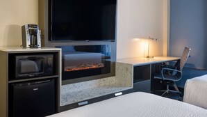 A hotel room with a flat-screen TV, a coffee maker, a microwave, a mini-fridge, a desk with a chair, and a fireplace. - Days Hotel by Wyndham North Bergen /NYC Area (North Bergen)