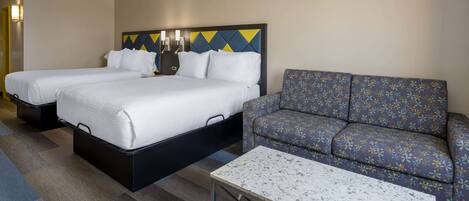 Una habitación de hotel con dos camas, un sofá y una mesita de café.