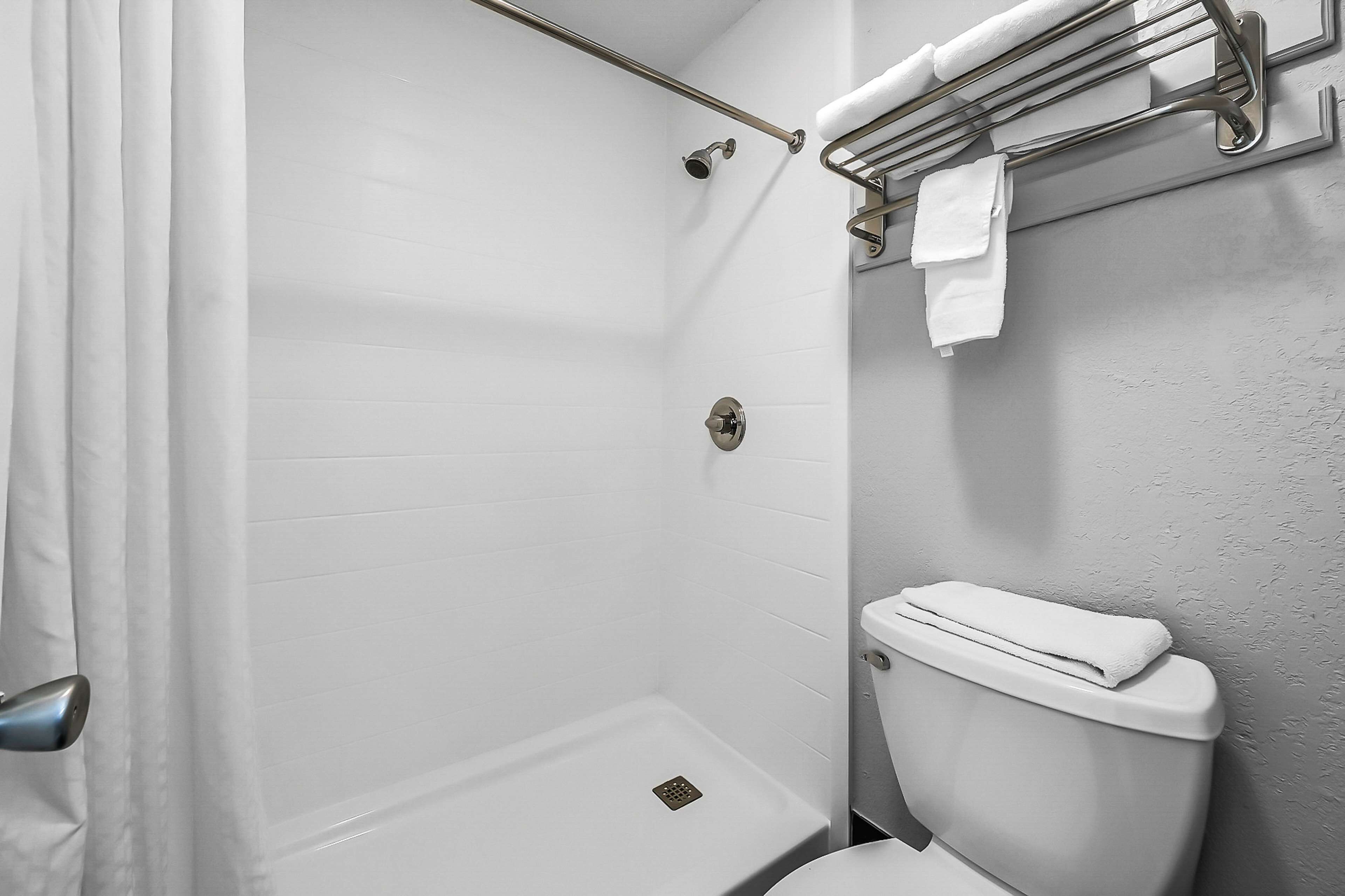 Ein Badezimmer mit Dusche, Toilette und Handtuchhalter.