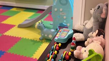 A play area with toys, a television, and a wall with star decorations.