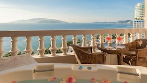 A balcony with a hot tub, wicker chairs, and a table with drinks. - Sunrise Nha Trang Beach Hotel & Spa (Nha Trang)