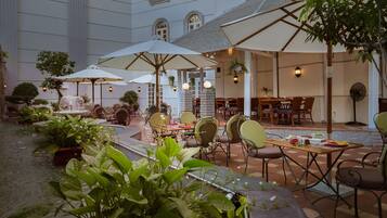 A courtyard with outdoor seating, umbrellas, and potted plants.