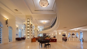 A spacious lobby with a grand piano, elegant chandeliers, and a curved staircase. - Sunrise Nha Trang Beach Hotel & Spa (Nha Trang)