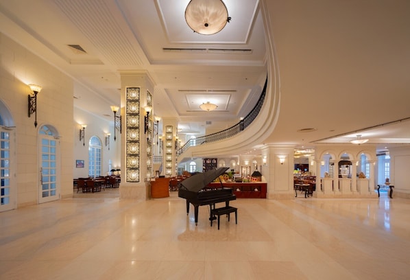 A spacious lobby with a grand piano, elegant chandeliers, and a curved staircase. - Sunrise Nha Trang Beach Hotel & Spa (Nha Trang)