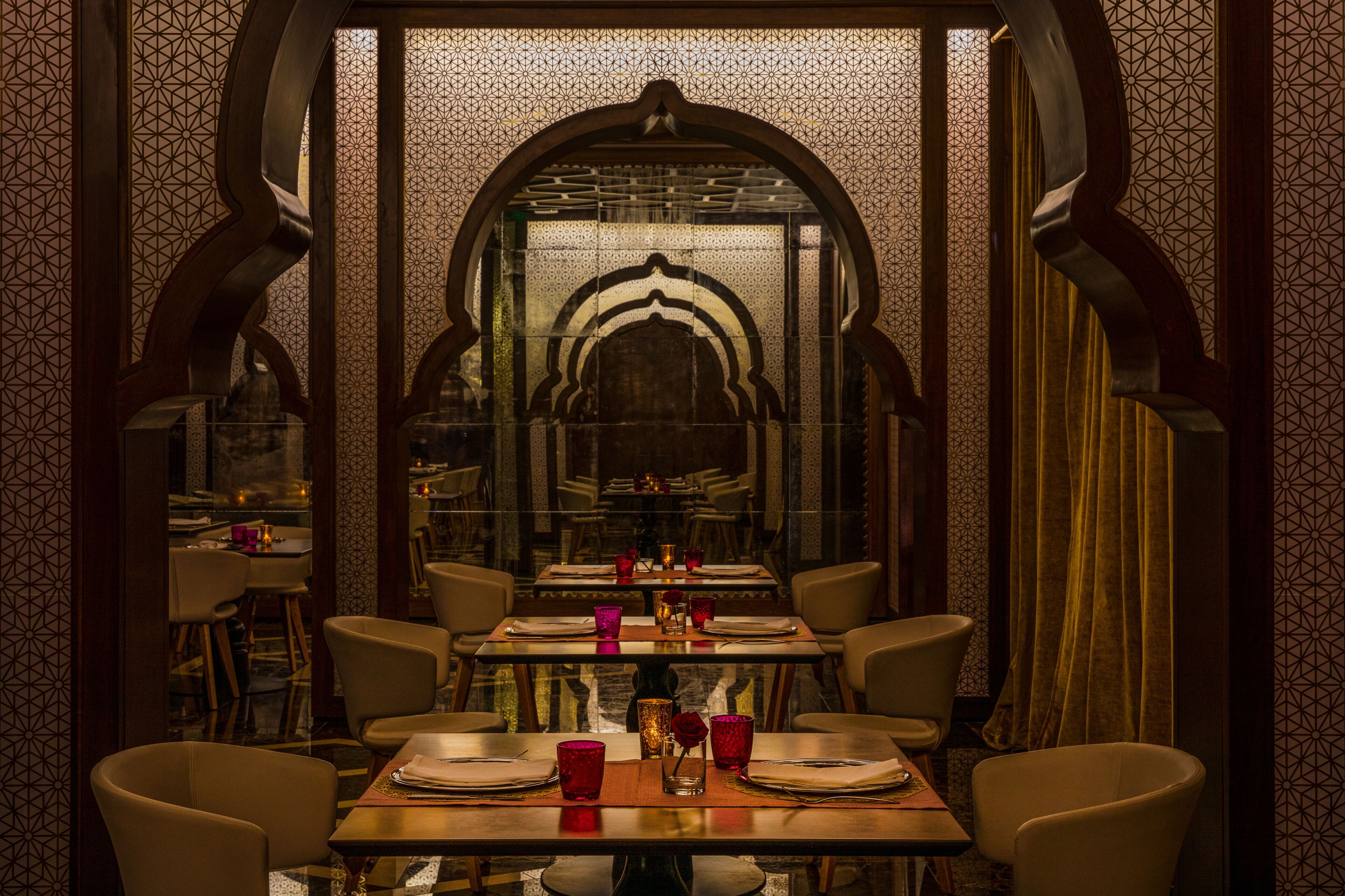 A restaurant with a central dining table set for four, surrounded by chairs.