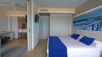 Una habitación de hotel moderna con una cama grande, un escritorio y una televisión.