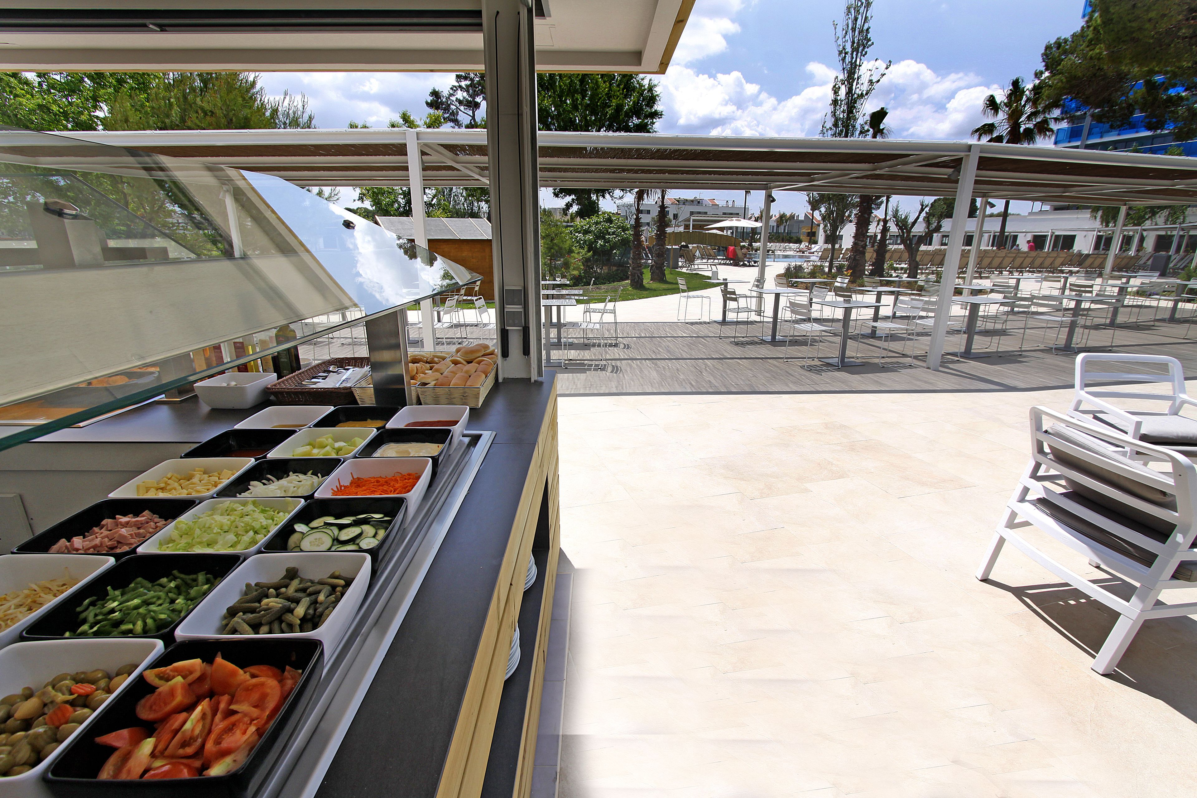 Een buffet met diverse gerechten en een overdekt terras.