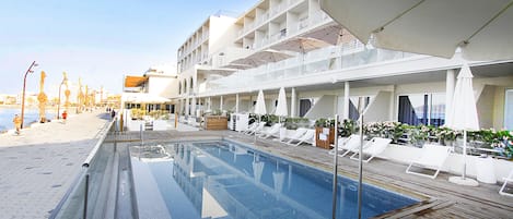 A pool area with lounge chairs and a wooden deck.