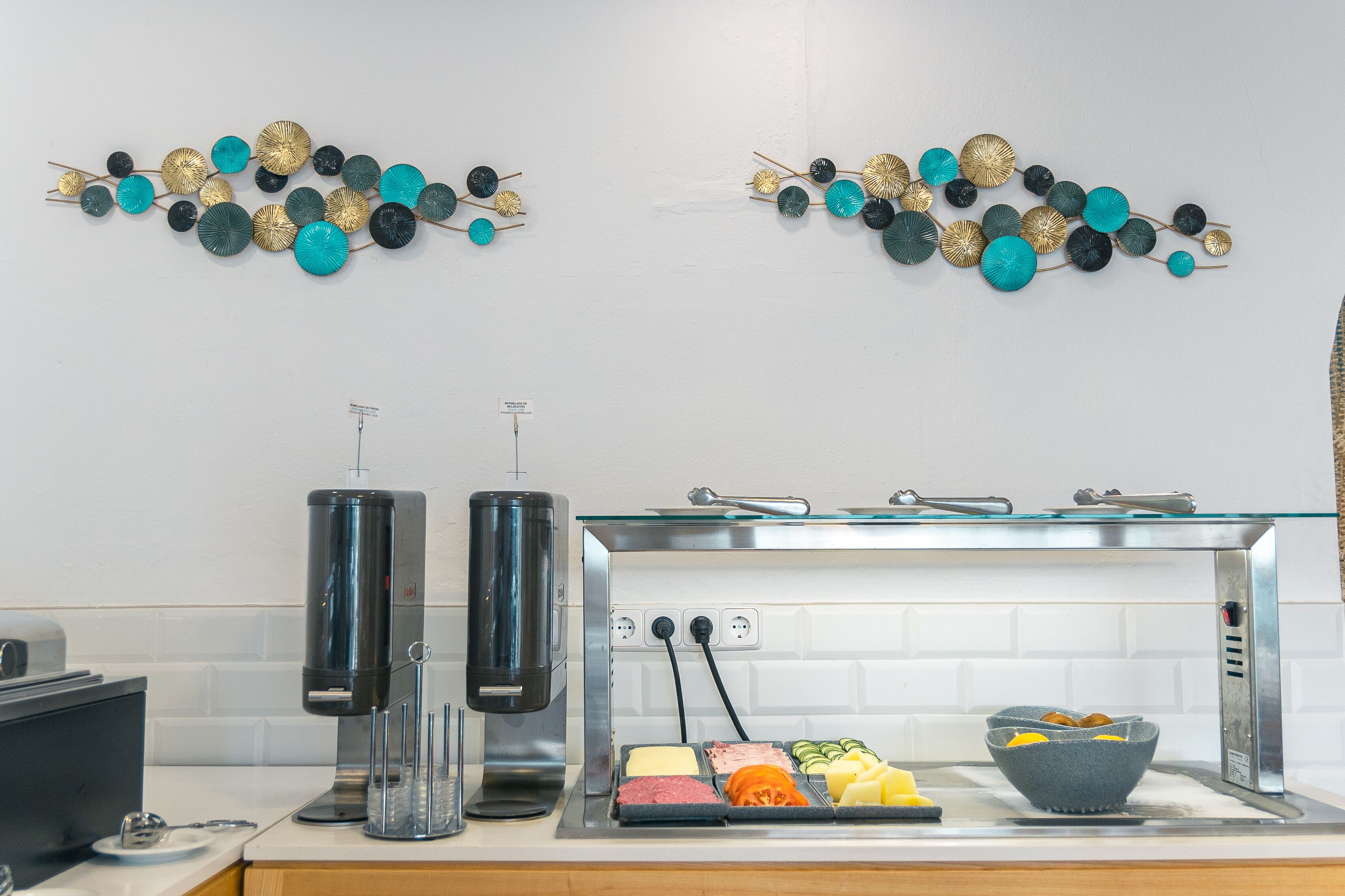 Une cuisine équipée d’une machine à café, d’un plan de travail en verre et d’un présentoir pour les aliments.