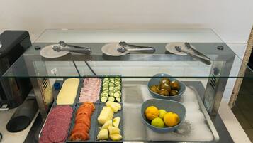 En buffé med ett varierat utbud av mat, inklusive kött, ostar och frukt.