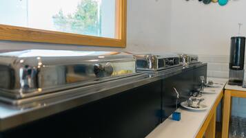Una cocina con una encimera larga, electrodomésticos de acero inoxidable y una ventana.