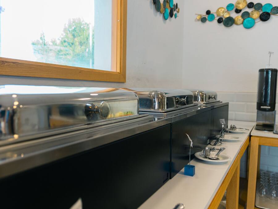 Una cocina con una encimera larga, electrodomésticos de acero inoxidable y una ventana.