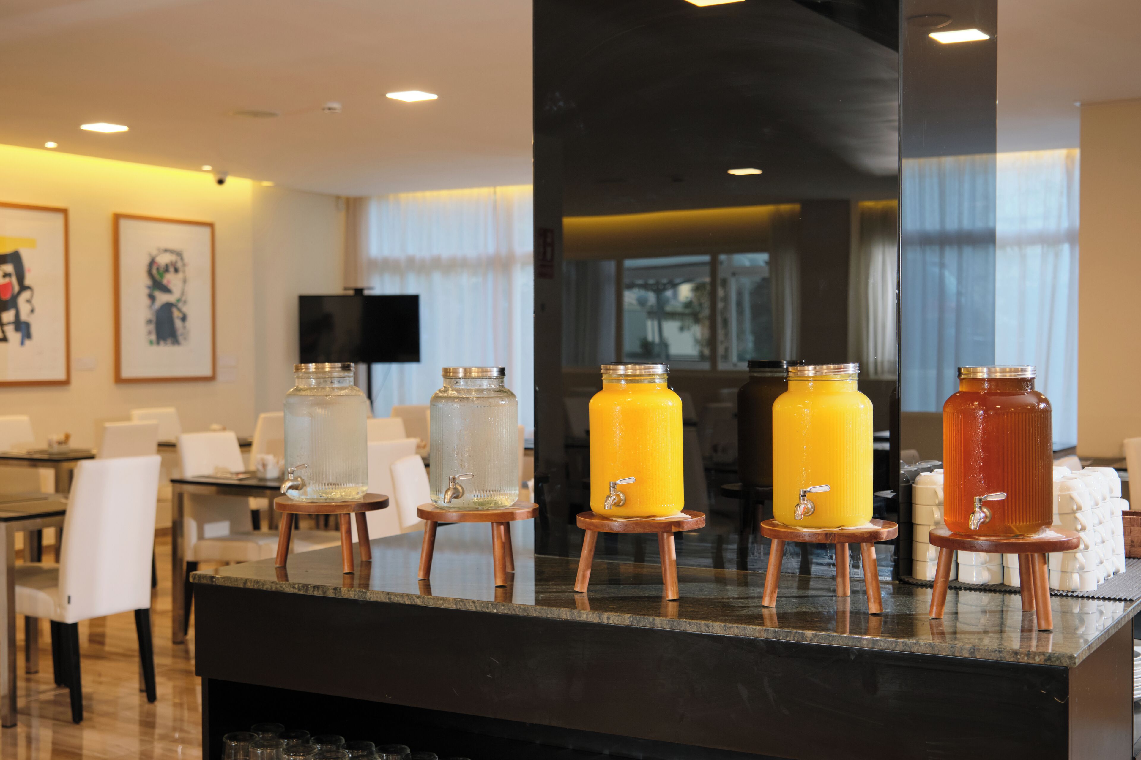 Un vestíbulo de hotel con un mostrador que exhibe varios dispensadores de bebidas.