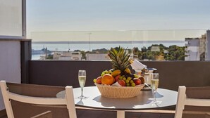 Un balcón con mesa para dos personas, con frutero y dos copas de champán.