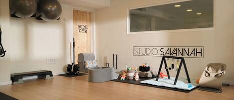 A gym with exercise equipment, a wooden wall, and a large window.