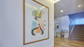 Una galería de arte moderno con un cuadro abstracto enmarcadosobre una pared blanca.