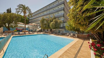 Een buitenzwembad, parasols bij het zwembad en ligstoelen