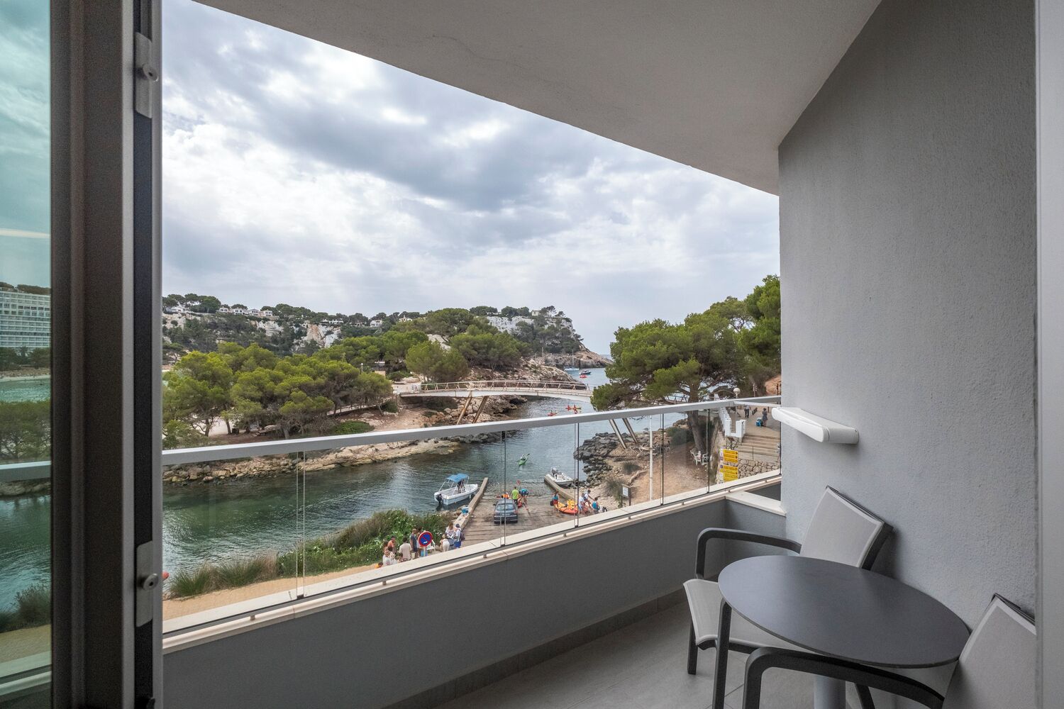 Un balcon avec vue sur une rivière, des bateaux et un pont.