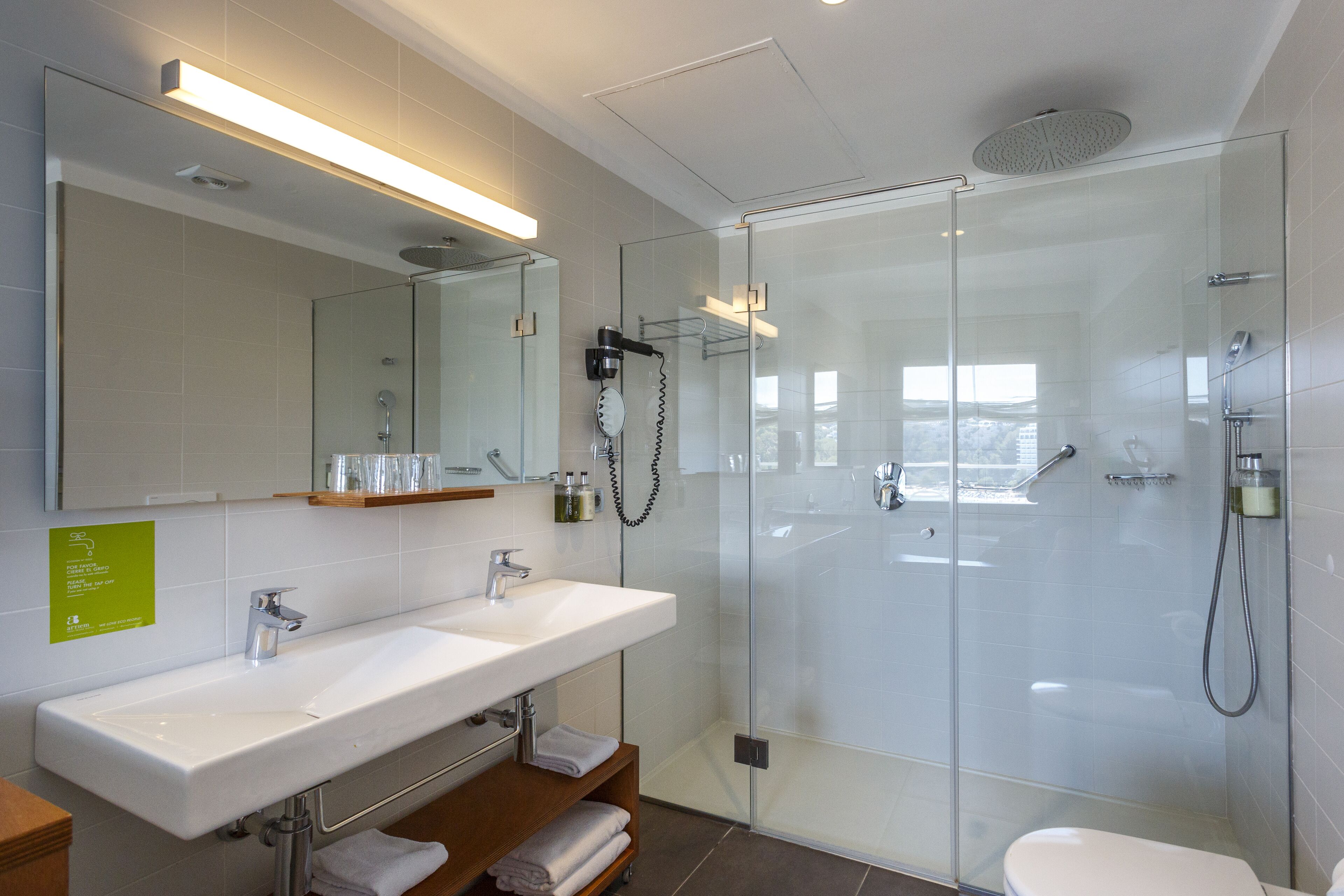 Une salle de bain moderne avec deux lavabos, une douche à l’italienne et des toilettes.