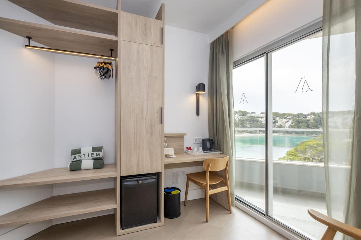 Une chambre moderne équipée d’un bureau, d’une chaise et offrant une vue sur la mer.