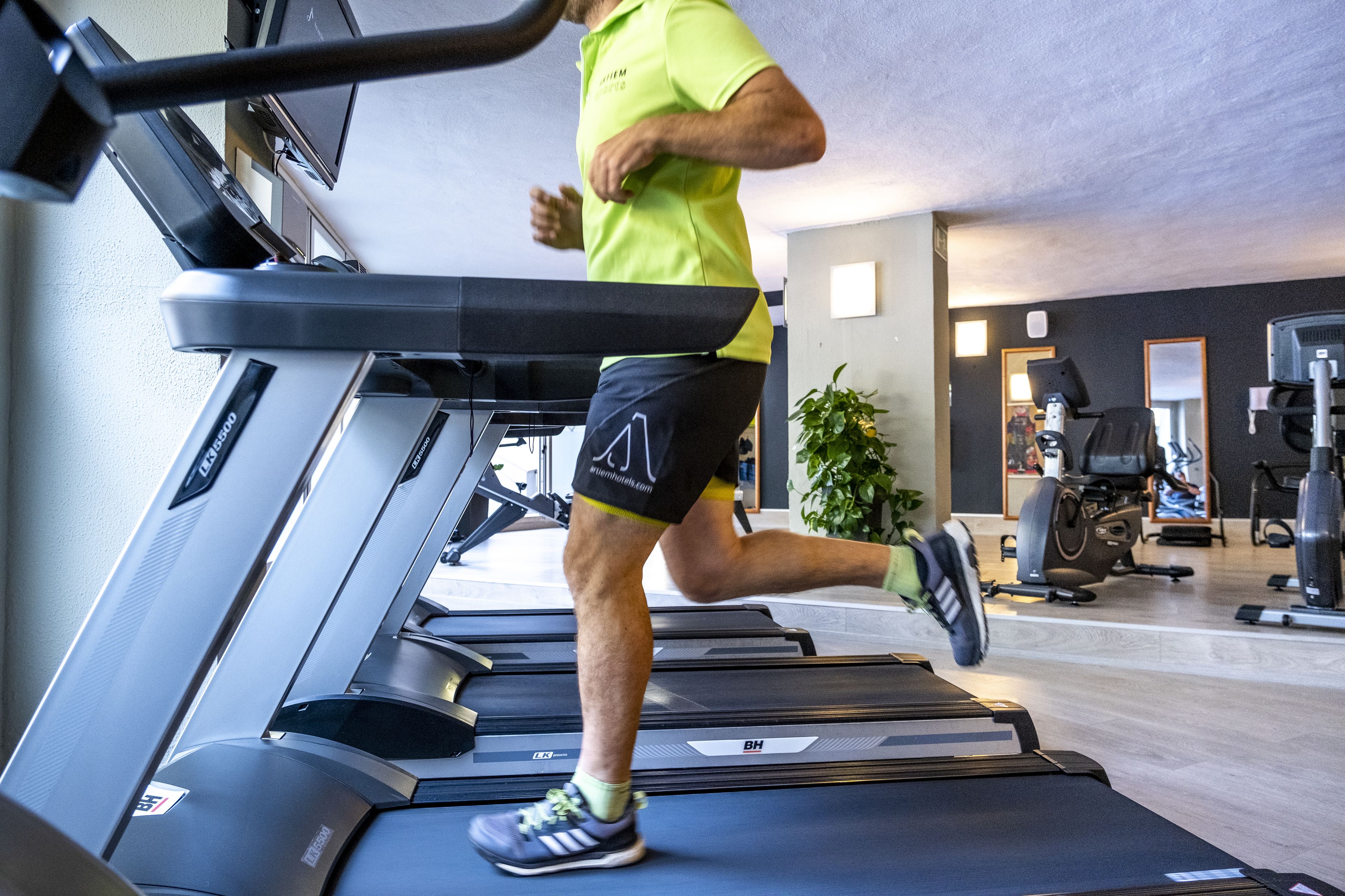 Et fitnesscenter med løbebånd, motionscykler og andet træningsudstyr.