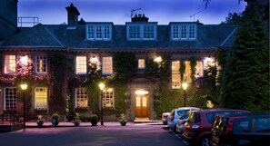 A historic building with a central entrance, multiple windows, and a parking area with cars. - Ellersly House Hotel (Edinburgh)