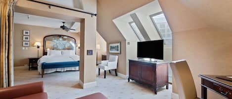 A hotel room with a bed, a desk, a television, and a chair.