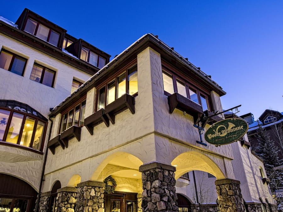 A hotel with a stone facade, multiple windows, and a sign indicating it is a Posten Montane luxury lodging.