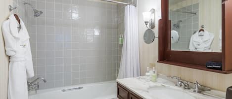 Une salle de bain moderne équipée d’une baignoire, d’une douche, d’un meuble-lavabo avec un miroir et d’un porte-serviettes.