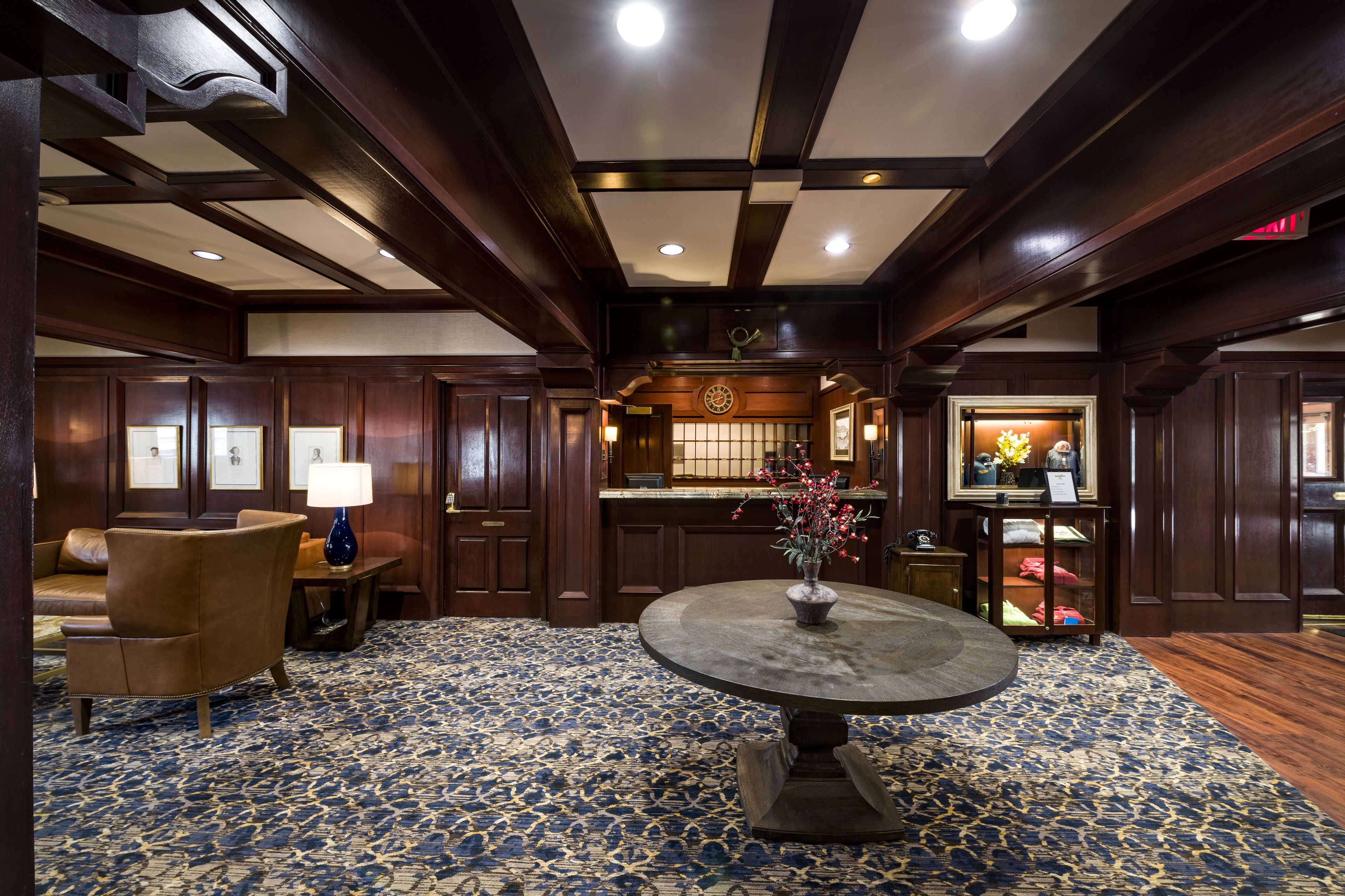 A lobby with a round table, a sofa, and a bar area.