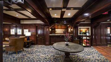 A lobby with a round table, a sofa, and a bar area.
