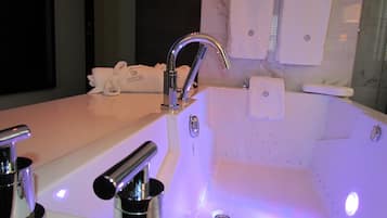 Ein modernes Badezimmer mit einer großen Badewanne, einem separaten Waschbecken und einer Dusche.