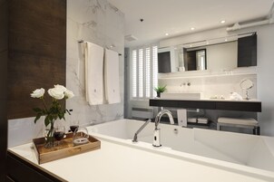 Un baño moderno con una bañera grande, un tocador doble y un espejo sobre el tocador.