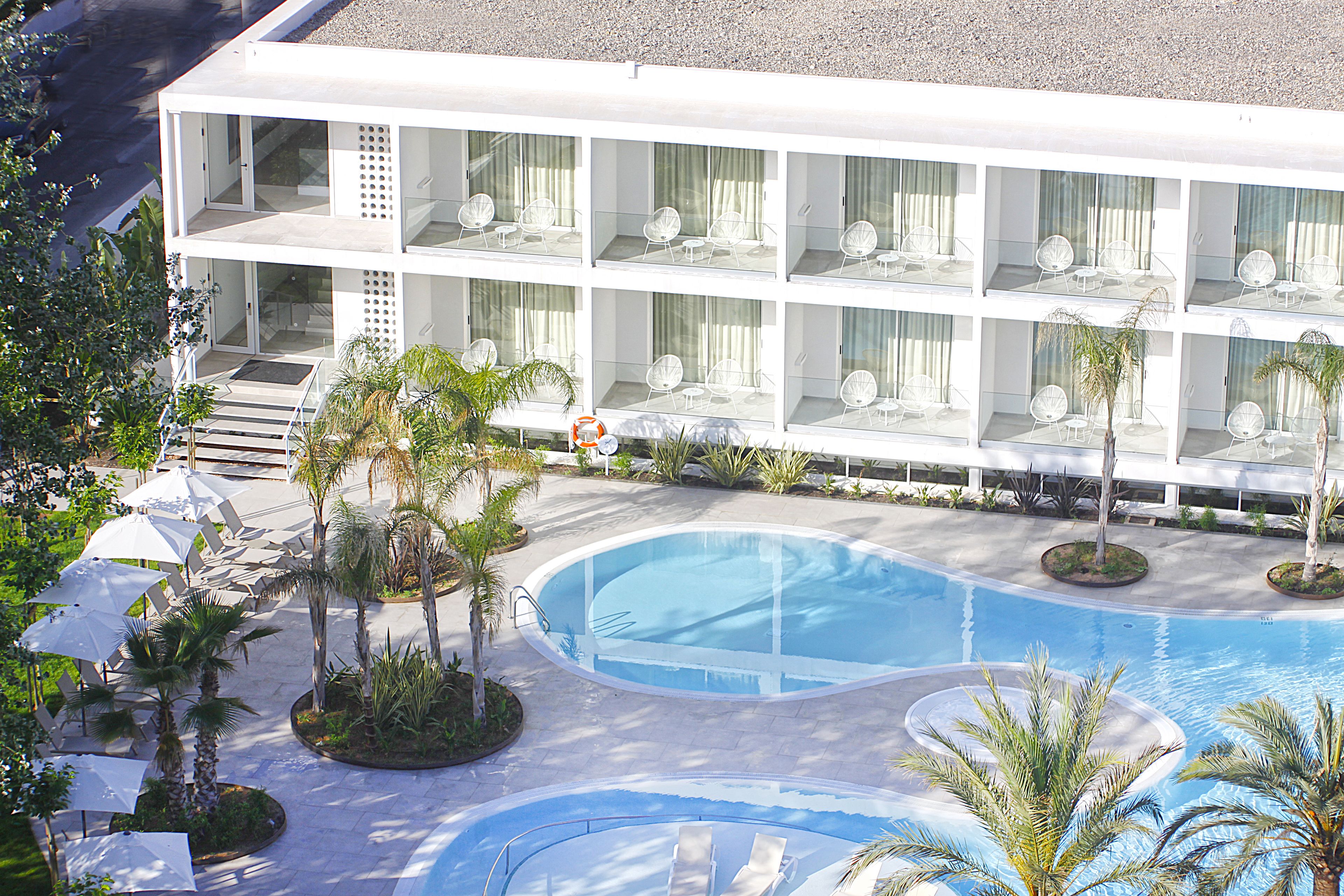 Ein Hotel mit mehreren Balkonen, einem Schwimmbad und Außenbereichen zum Sitzen.