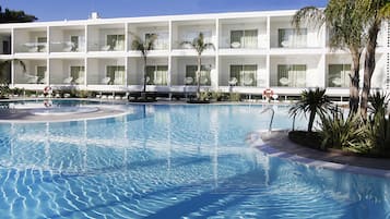 Een binnenzwembad, een buitenzwembad en parasols bij het zwembad