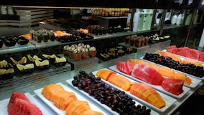 Une variété de fruits et de pâtisseries présentés sur un buffet.