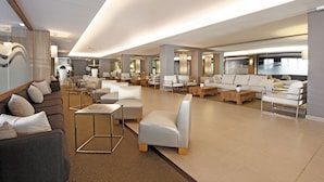 A spacious lobby with multiple seating areas, including sofas and armchairs, arranged in a modern layout. - BG Hotel Caballero (Palma de Mallorca)