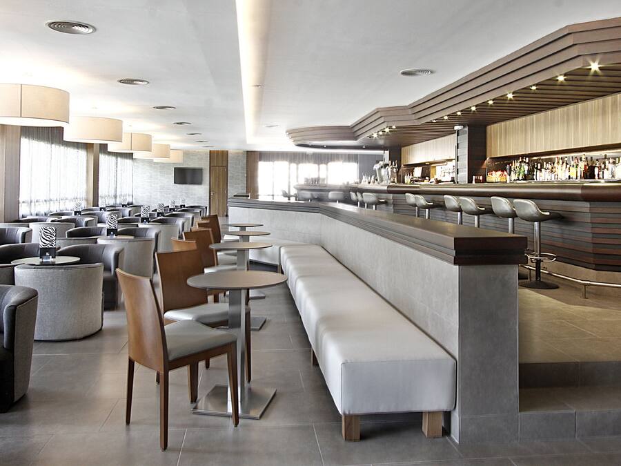 Eine moderne Bar mit Sitzgelegenheiten und einer Theke.