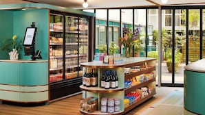 Un espace de vente moderne, doté d’un comptoir de couleur turquoise, d’une vitrine réfrigérée et proposant une variété de produits, notamment des boissons et des en-cas.