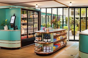 A modern retail space with a self-service kiosk, refrigerated wine section, and shelves stocked with snacks and beverages. - Avani Museum Quarter Amsterdam Hotel (Amsterdam)