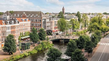 A canal with a bridge, surrounded by historic buildings and trees.