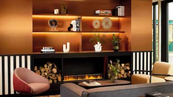 Una sala de estar moderna con chimenea, estanterías, un sofá y una mesa de centro.