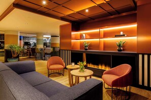 A modern lounge area with a fireplace, comfortable seating, and a well-lit ambiance. - Avani Museum Quarter Amsterdam Hotel (Amsterdam)