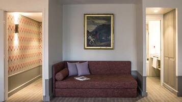 Una habitación de hotel moderna con un sofá rojo, un cuadro enmarcado y una pared con diseño.