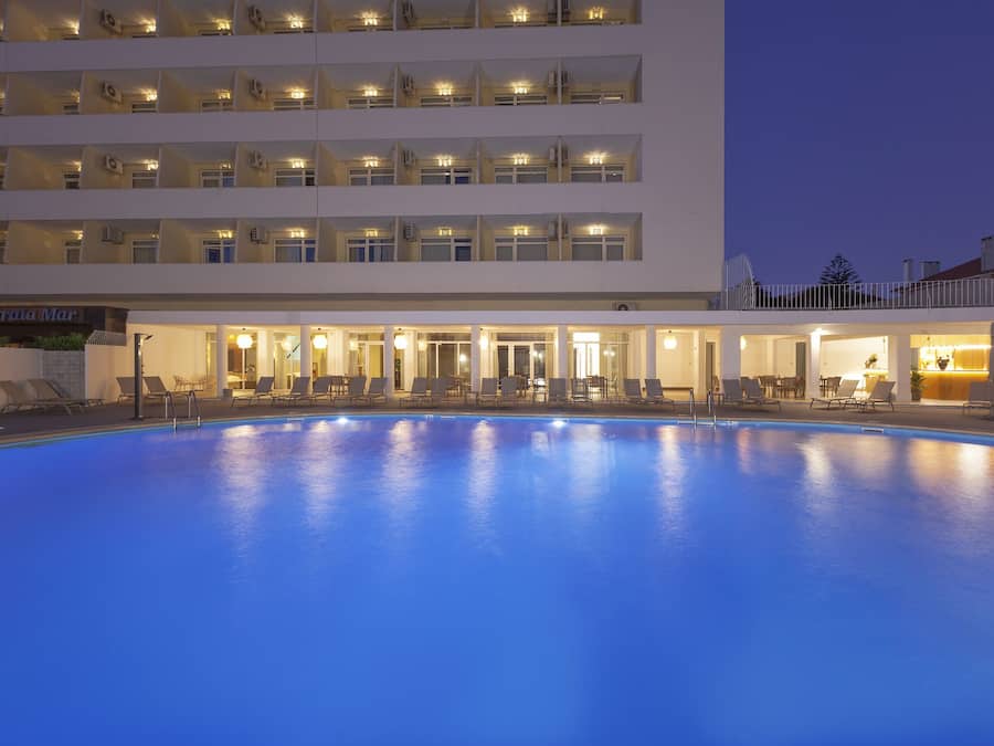 Un hôtel doté d’une piscine, de plusieurs balcons et d’un espace de réception.