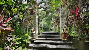 A staircase leading up to a temple-like structure surrounded by lush greenery. - Bali Spirit Hotel & Spa (Ubud)
